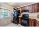 A kitchen featuring wood cabinetry, black appliances, and a window providing natural light at 5265 E Bay Dr # 521, Clearwater, FL 33764