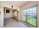 Sunny living room featuring large windows with views of lush greenery, stylish light fixture, and light wood-look flooring at 5265 E Bay Dr # 521, Clearwater, FL 33764