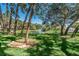 Scenic view of the community pond with a fountain, surrounded by mature trees and green grass at 5265 E Bay Dr # 521, Clearwater, FL 33764