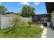 Landscaped backyard with flourishing trees, grass and an outside air conditioning unit at 7022 Kingsway Dr, Port Richey, FL 34668