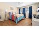 Cozy bedroom features bright bedding, natural light, and wood flooring at 7022 Kingsway Dr, Port Richey, FL 34668