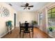 Well-lit dining room featuring hardwood floors, a ceiling fan, and a view of the outdoors at 7022 Kingsway Dr, Port Richey, FL 34668