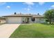 Charming single-story home featuring a lush front lawn and attached two-car garage at 7022 Kingsway Dr, Port Richey, FL 34668