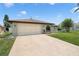 Charming single-story home featuring a lush front lawn and an attached two-car garage at 7022 Kingsway Dr, Port Richey, FL 34668