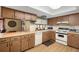 Functional kitchen with wood cabinetry, efficient appliances, and eat-in counter at 7022 Kingsway Dr, Port Richey, FL 34668