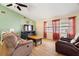 Cozy living room featuring wood-look flooring, ceiling fan and plenty of natural light at 7022 Kingsway Dr, Port Richey, FL 34668