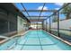 Relaxing screened-in pool area with a calming chandelier for evening swims at 7022 Kingsway Dr, Port Richey, FL 34668
