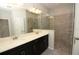 A luxurious bathroom featuring a double sink vanity and a tiled glass-enclosed shower at 723 Steel Dr, Apollo Beach, FL 33572