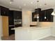 Modern kitchen boasting sleek, dark cabinetry, stainless steel appliances, and a bright white countertop island at 723 Steel Dr, Apollo Beach, FL 33572
