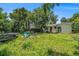 View of the backyard, showing grassy yard and exterior of the home at 814 Florida Ave, Palm Harbor, FL 34683