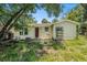 Modest exterior of a yellow home with a red door and front yard at 814 Florida Ave, Palm Harbor, FL 34683