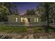 Charming single-story home featuring a cozy front porch and mature trees at twilight at 814 Florida Ave, Palm Harbor, FL 34683