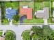 Aerial view of a single-story home with a red roof, surrounded by green lawns and other houses at 855 Pinewood W Ter, Palm Harbor, FL 34683