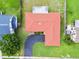 Aerial view of a home showing its roof, a long driveway, and a well-maintained yard surrounded by greenery at 855 Pinewood W Ter, Palm Harbor, FL 34683