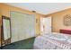 Bedroom featuring a closet, mirror, a view into an adjacent room, and warm, neutral walls at 855 Pinewood W Ter, Palm Harbor, FL 34683