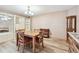 Bright dining area featuring wood table, chairs, display cabinets, and light wood flooring at 855 Pinewood W Ter, Palm Harbor, FL 34683