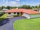 Well-maintained home with red roof, green lawn and large driveway at 855 Pinewood W Ter, Palm Harbor, FL 34683