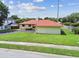 Single story home with a red roof and attached garage from a rear angle at 855 Pinewood W Ter, Palm Harbor, FL 34683