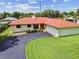 Well-maintained home with red roof, front yard and long driveway at 855 Pinewood W Ter, Palm Harbor, FL 34683