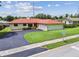 Charming home featuring a red roof, green lawn, and an attached garage at 855 Pinewood W Ter, Palm Harbor, FL 34683