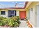 Close-up of front door surrounded by vibrant flowers and a bay window, enhancing curb appeal at 855 Pinewood W Ter, Palm Harbor, FL 34683
