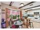 Bright eat-in kitchen features white cabinets, modern appliances, dark wood beams, and tile floors at 855 Pinewood W Ter, Palm Harbor, FL 34683
