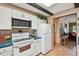 Kitchen with white appliances, cabinets and dark wood beams plus an adjacent living space at 855 Pinewood W Ter, Palm Harbor, FL 34683