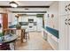 Bright eat-in kitchen features white cabinets, modern appliances, dark wood beams, and tile floors at 855 Pinewood W Ter, Palm Harbor, FL 34683
