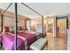 Elegant bedroom featuring a four-poster bed, complementing furniture, and access to a bathroom at 855 Pinewood W Ter, Palm Harbor, FL 34683