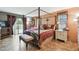 Elegant bedroom featuring a four-poster bed, complementing furniture, and sliding glass doors to the outside at 855 Pinewood W Ter, Palm Harbor, FL 34683