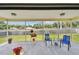 Enclosed back porch overlooking a well maintained backyard with blue chairs at 855 Pinewood W Ter, Palm Harbor, FL 34683