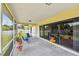 Relaxing screened patio with tile flooring and sliding glass doors, offering seamless indoor-outdoor living at 855 Pinewood W Ter, Palm Harbor, FL 34683