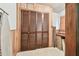 Storage room with slat doors, wooden paneled walls and tile floors at 855 Pinewood W Ter, Palm Harbor, FL 34683