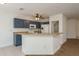 Open kitchen showcasing blue cabinets, an island with counter seating, white appliances, and tiled flooring at 9630 Carlsdale Dr, Riverview, FL 33578