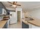 Bright kitchen with blue cabinetry, white appliances, a pantry, and an island with a double sink at 9630 Carlsdale Dr, Riverview, FL 33578