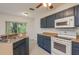 Bright kitchen features tile floors, blue cabinets, and white appliances at 9630 Carlsdale Dr, Riverview, FL 33578