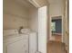 This laundry room features shelving, a door to another room, and a washer and dryer at 9630 Carlsdale Dr, Riverview, FL 33578