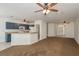 Open-concept living area features neutral paint, ceiling fans, and tile flooring near the kitchen space at 9630 Carlsdale Dr, Riverview, FL 33578