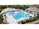 Large community pool with plenty of seating, umbrellas, and views of a nearby pond at 9630 Carlsdale Dr, Riverview, FL 33578