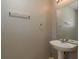 Neutral powder room with pedestal sink, mirror, towel bar, and ceramic tile flooring at 9630 Carlsdale Dr, Riverview, FL 33578