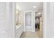 Bright white bathroom featuring a vanity and walk-in closet with ample storage space at 1 Key Capri # 302E, Treasure Island, FL 33706