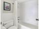 All-white bathroom with a shower-tub combo and tiled walls at 1 Key Capri # 302E, Treasure Island, FL 33706