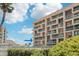 Condo exterior featuring multiple stories, manicured hedges, and teal balconies at 1 Key Capri # 302E, Treasure Island, FL 33706