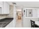 Bright kitchen featuring tile backsplash, black countertops and white cabinets with an opening to the dining room at 1 Key Capri # 302E, Treasure Island, FL 33706