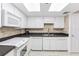 Well-equipped kitchen with white cabinets, modern appliances, and light tile floors at 1 Key Capri # 302E, Treasure Island, FL 33706