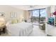 A bright main bedroom featuring light walls, carpet and a glass door to the balcony at 1 Key Capri # 302E, Treasure Island, FL 33706