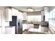 Modern kitchen featuring stainless steel appliances, granite counters, and white cabinetry at 10502 Orange Blossom Ln, Seminole, FL 33772
