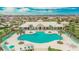 Aerial view of a community pool and clubhouse, featuring ample seating and lush palm trees against a backdrop of homes at 11019 Leland Groves Dr, Riverview, FL 33579