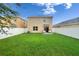 Spacious backyard offering privacy with a white fence, complemented by a manicured lawn and outdoor seating at 11019 Leland Groves Dr, Riverview, FL 33579