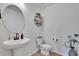 Bright powder room featuring a stylish pedestal sink and modern fixtures at 11019 Leland Groves Dr, Riverview, FL 33579